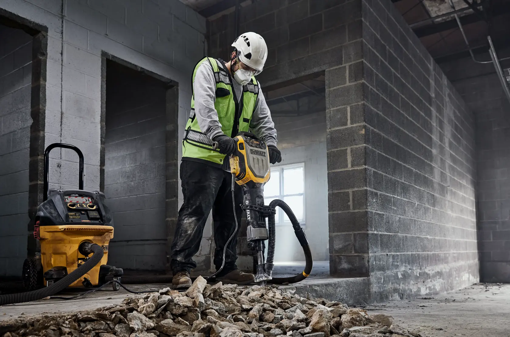 Trabajador usa DEWALT D25966, D25966-B2 para romper escombros. Sitio en construcción.