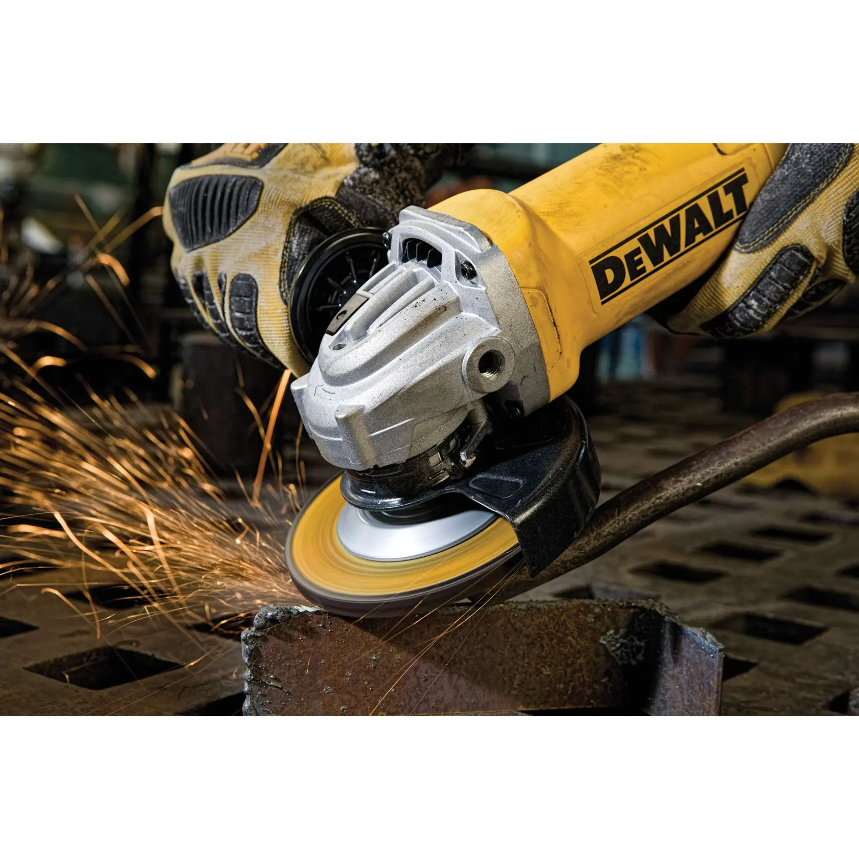 Primer plano de una amoladora angular DEWALT en uso, produciendo chispas mientras pule una pieza de metal. La herramienta es manipulada por una persona que lleva guantes de protección.